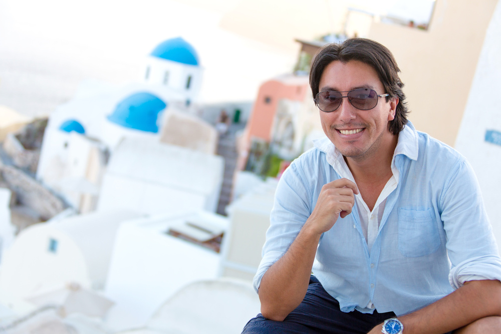 Happy man in Santorini enjoying his summer holidays